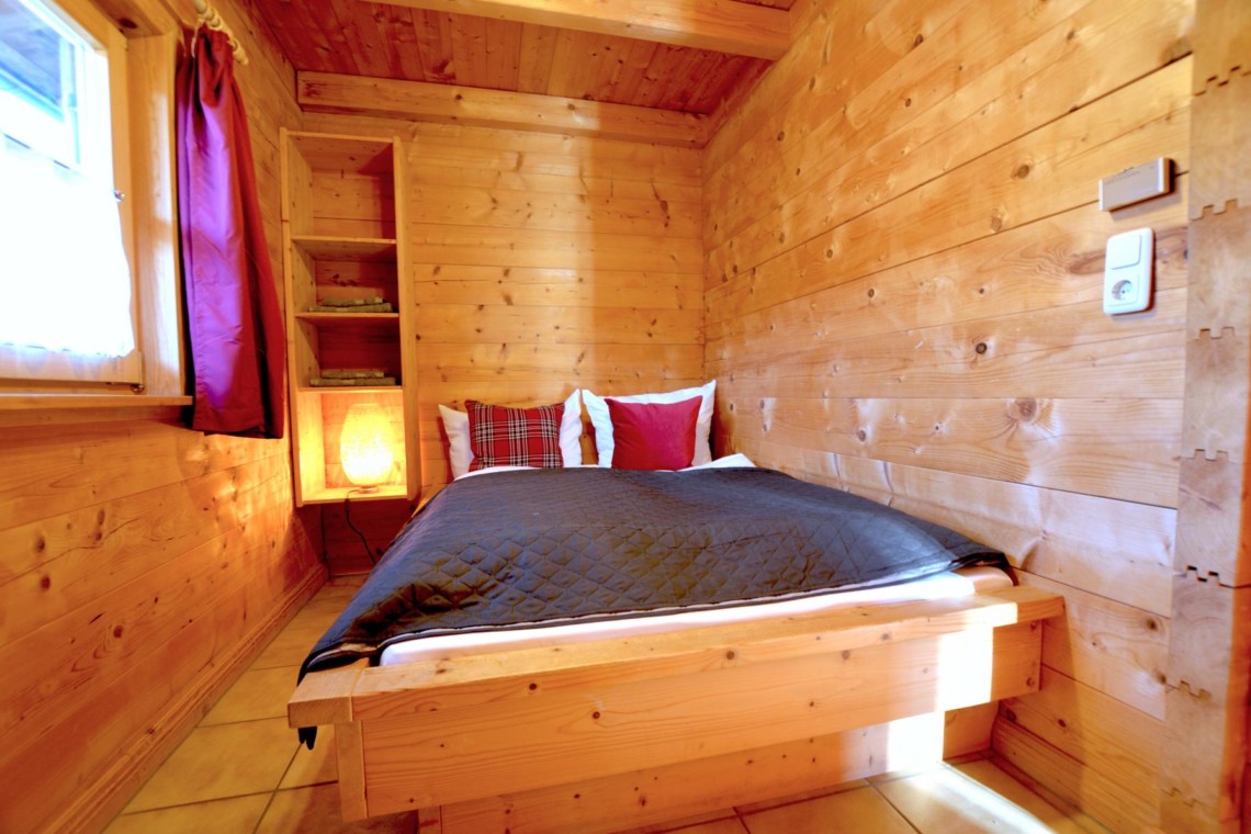 Gemütliches Holz-Schlafzimmer in Schliersee Ferienwohnung mit WLAN und idyllischem Bergblick.