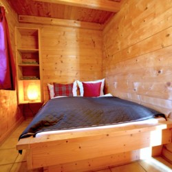 Gemütliches Holzschlafzimmer im Panoramachalet, Schliersee – perfekt für einen entspannten Urlaub.