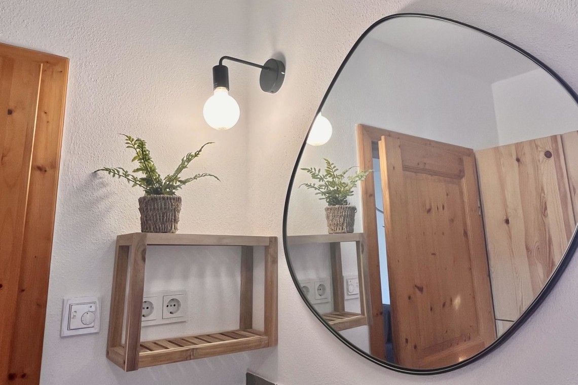 Gemütliches Interieur mit Holzelementen, moderner Beleuchtung und Spiegel – ideal für Entspannung in Bayrischzell.
