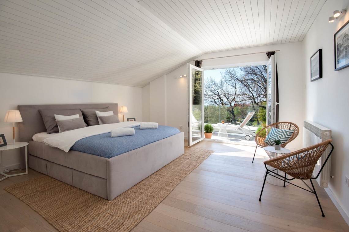 Gemütliches Schlafzimmer in Opatija Ferienwohnung, modernes Design, Terrassenzugang, helle Atmosphäre.
