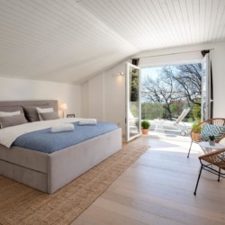 Gemütliches Schlafzimmer in Opatija Ferienwohnung, modernes Design, Terrassenzugang, helle Atmosphäre.