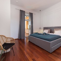 Gemütliches Apartment in Opatija: stilvolles Schlafzimmer mit Doppelbett, modernem Design, Parkettboden & Balkonzugang. Ideal für Paare.