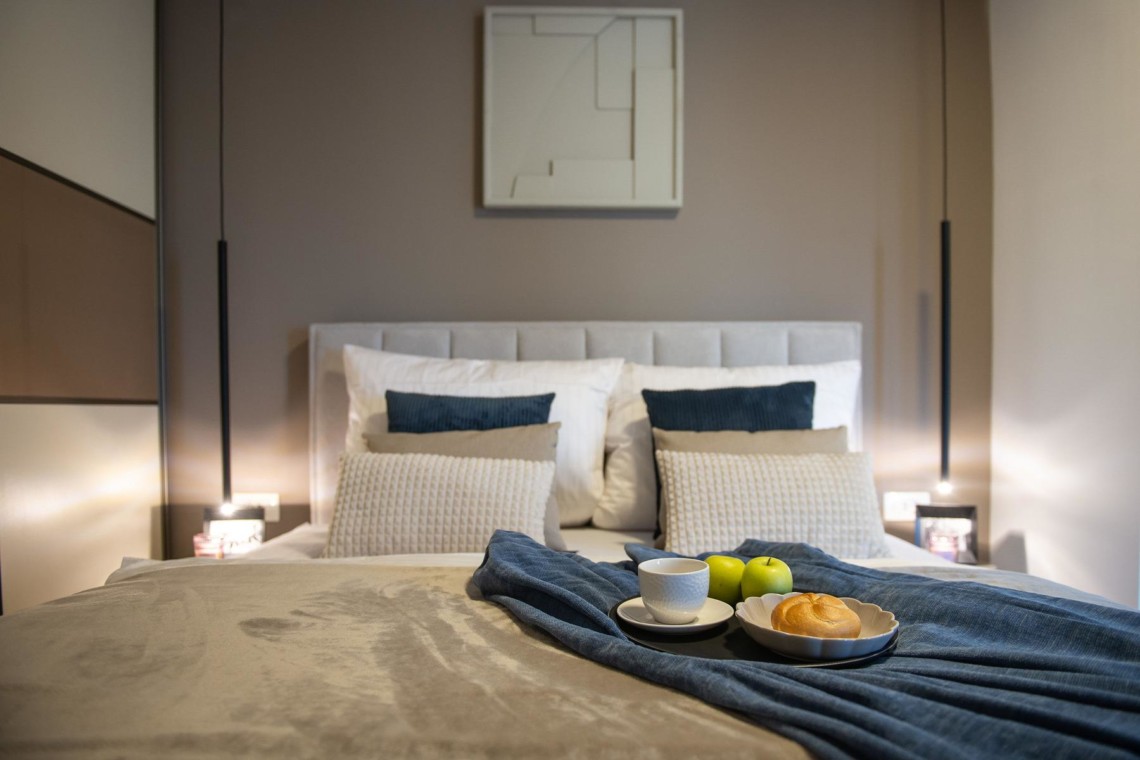 Modernes Apartment in Opatija, gemütliches Schlafzimmer mit Frühstück am Bett. Ideal für eine erholsame Urlaubserfahrung.