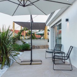 Gemütliche Terrasse mit Sonnenschirm und Sitzgelegenheiten in Opatija. Ideal für entspannten Urlaub.