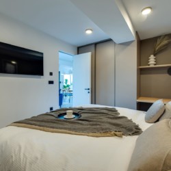 Modernes Apartment in Opatija mit stilvollem Schlafzimmer, Balkonzugang und Flachbild-TV.