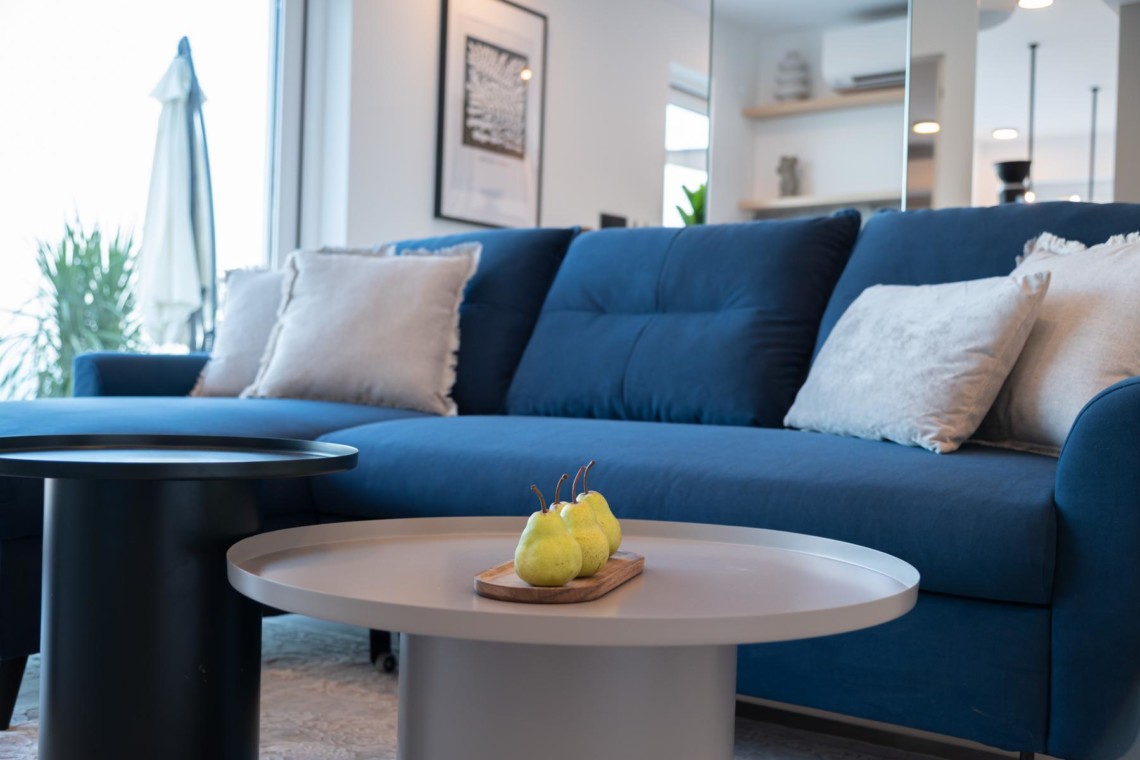 Elegantes Apartment in Opatija mit blauem Sofa, modernem Dekor und Meerblick für einen gemütlichen Urlaub.
