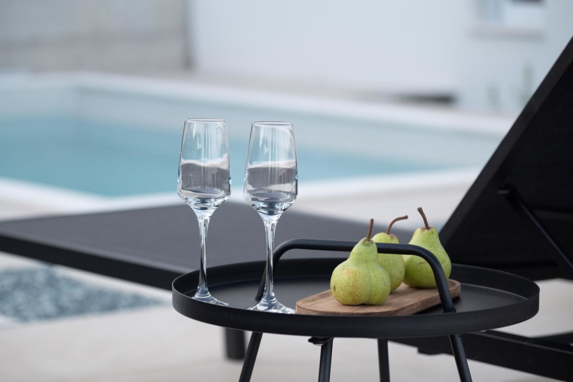 Gemütliches Ambiente am Pool in Opatija: leere Gläser und frische Birnen laden zum Entspannen ein.