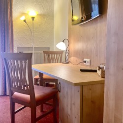 Gemütliches Zimmer in Schliersee mit Holzmöbeln & TV, ideal für Ihren Bergurlaub.