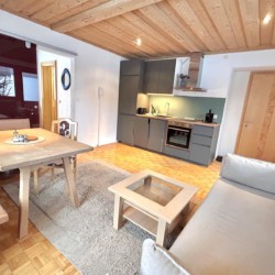 Gemütliches, helles Wohnzimmer mit Küche in einer Ferienwohnung in Warth am Arlberg. Ideal für Urlaub in den Alpen.