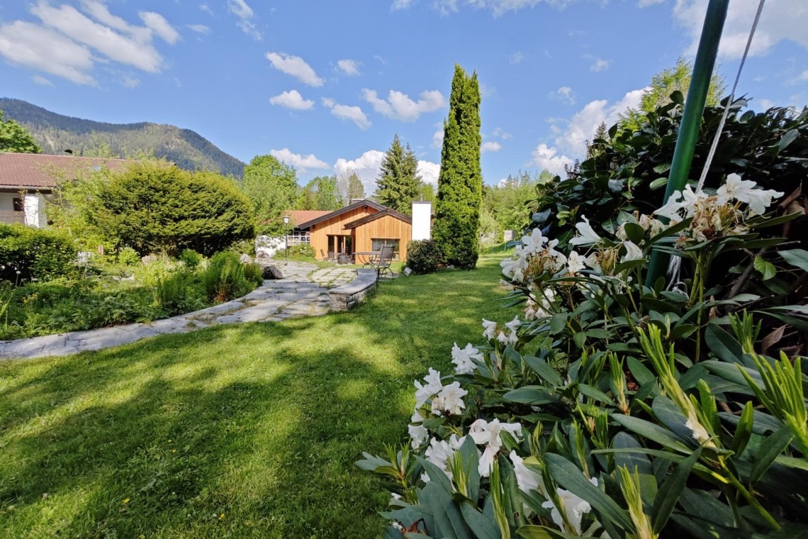 Idyllisches Ferienhaus mit blühendem Garten und Bergblick – perfekter Erholungsort für Urlauber.