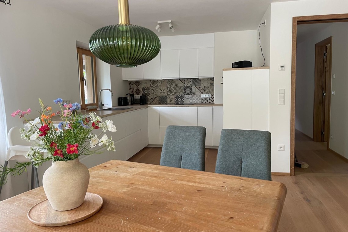 Gemütliche Ferienwohnung mit moderner Küche und stilvollem Esstisch, ideal für Erholung am Schliersee.
