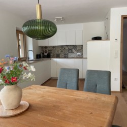 Gemütliche Ferienwohnung mit moderner Küche und stilvollem Esstisch, ideal für Erholung am Schliersee.