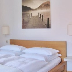 Gemütliches Schlafzimmer mit Doppelbett und Wandbild für entspannten Urlaub.