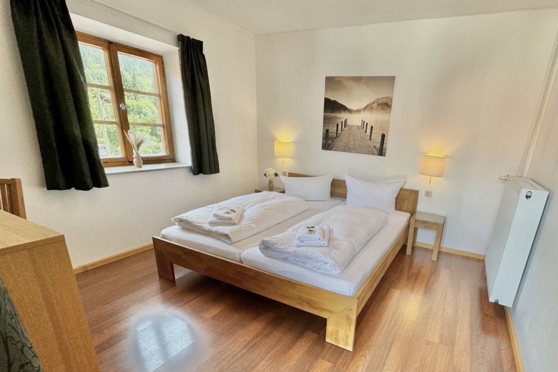 Gemütliches Schlafzimmer in einer Ferienwohnung mit Holzmobiliar und hellem Interieur. Ideal für Erholungssuchende.