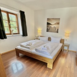 Gemütliches Schlafzimmer in einer Ferienwohnung mit Holzmobiliar und hellem Interieur. Ideal für Erholungssuchende.