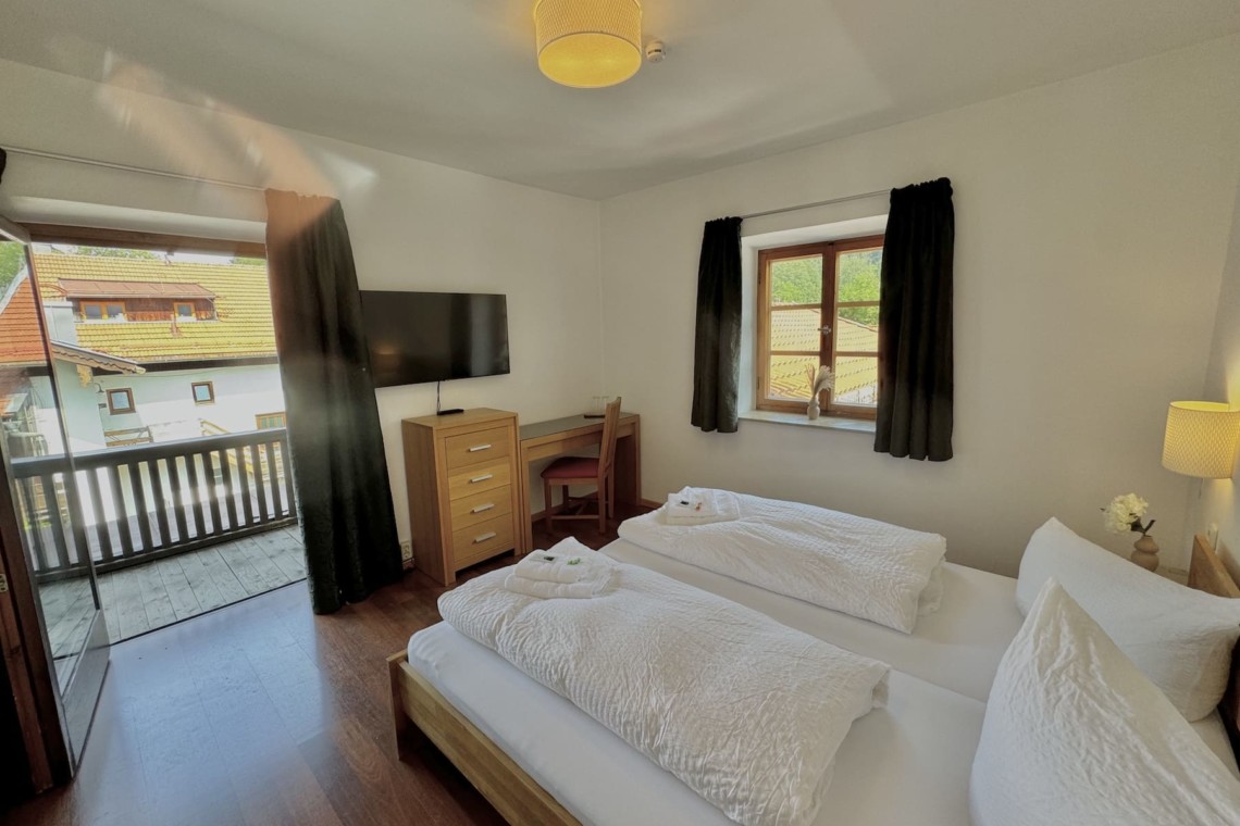 Gemütliches Schlafzimmer in Ferienwohnung mit Balkon und TV. Ideal für Erholung und Entspannung.