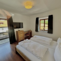 Gemütliches Schlafzimmer in Ferienwohnung mit Balkon und TV. Ideal für Erholung und Entspannung.