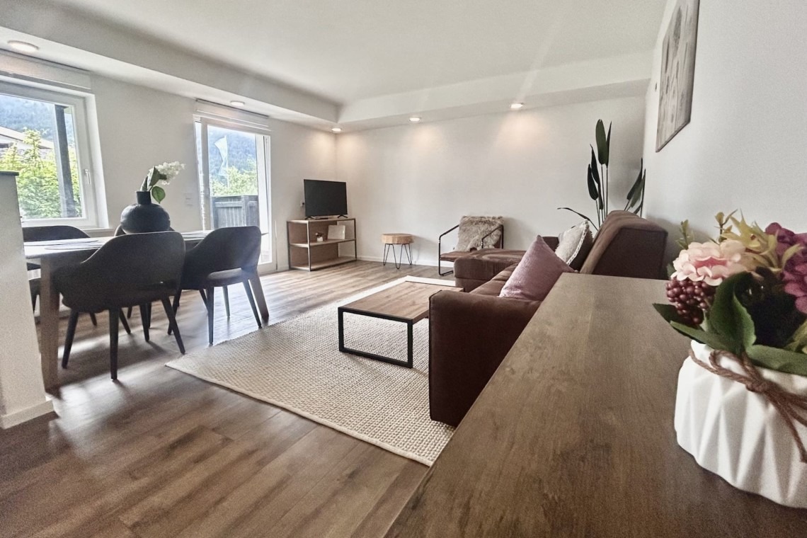Helles, stilvolles Wohnzimmer mit modernen Möbeln und Bergblick – ideal für Entspannung am Spitzingsee.