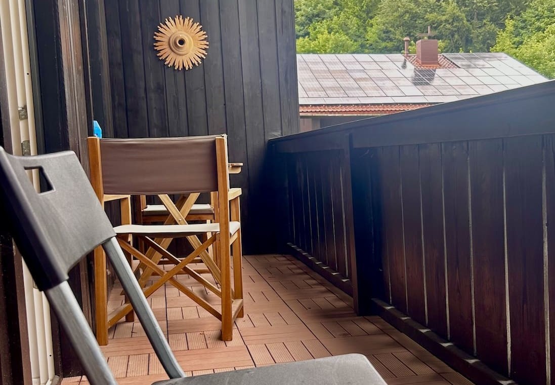 Gemütlicher Balkon einer Ferienwohnung mit Blick auf grüne Natur – ideal für Erholung.