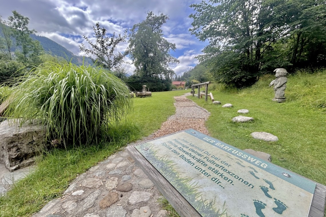 Gemütlicher Ferienwohnungsgarten "Mitterberg" mit idyllischem Weg, Grünfläche und Bergblick für Erholung pur.