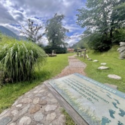 Gemütlicher Ferienwohnungsgarten "Mitterberg" mit idyllischem Weg, Grünfläche und Bergblick für Erholung pur.