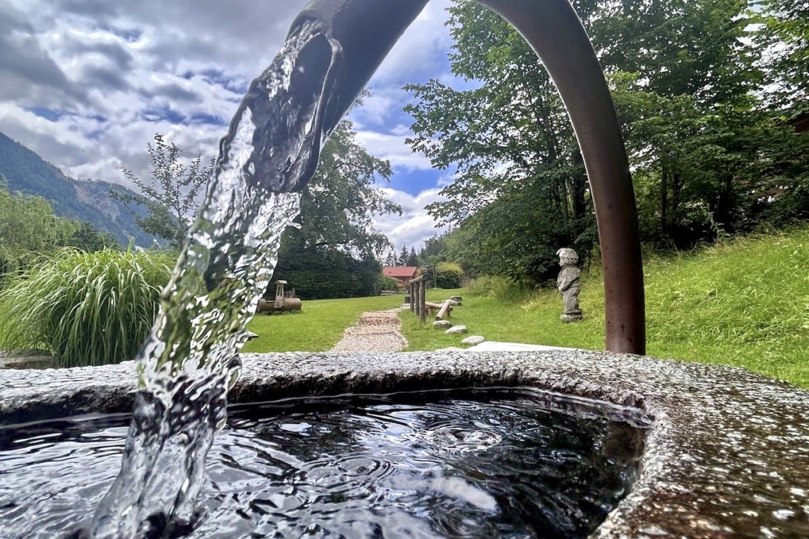 Idyllisches Brunnenwasser in grüner Natur – perfekte Ruheoase für Ihren Thiersee-Urlaub in der Königslinde. Buchen Sie jetzt auf stayfritz.com!