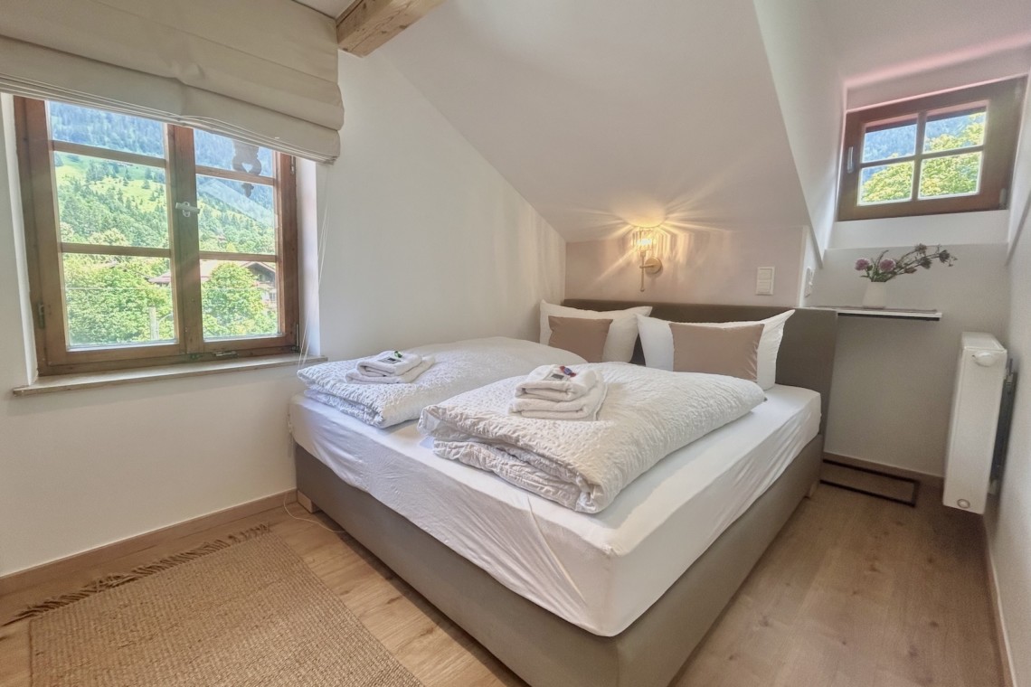 Helles, gemütliches Schlafzimmer mit Bergblick, ideal für die Suche nach Ruhe und Komfort.