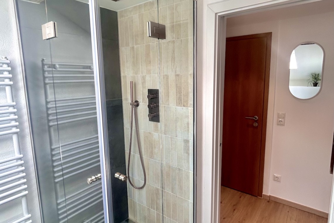 Modernes Badezimmer in Ferienwohnung mit eleganter Dusche, ideal für Entspannung auf dem Mitterberg.