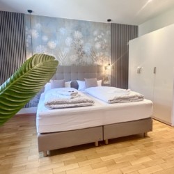 Gemütliches, stilvolles Zimmer in der Ferienwohnung "Die Königslinde" mit komfortablem Bett und eleganter Einrichtung.