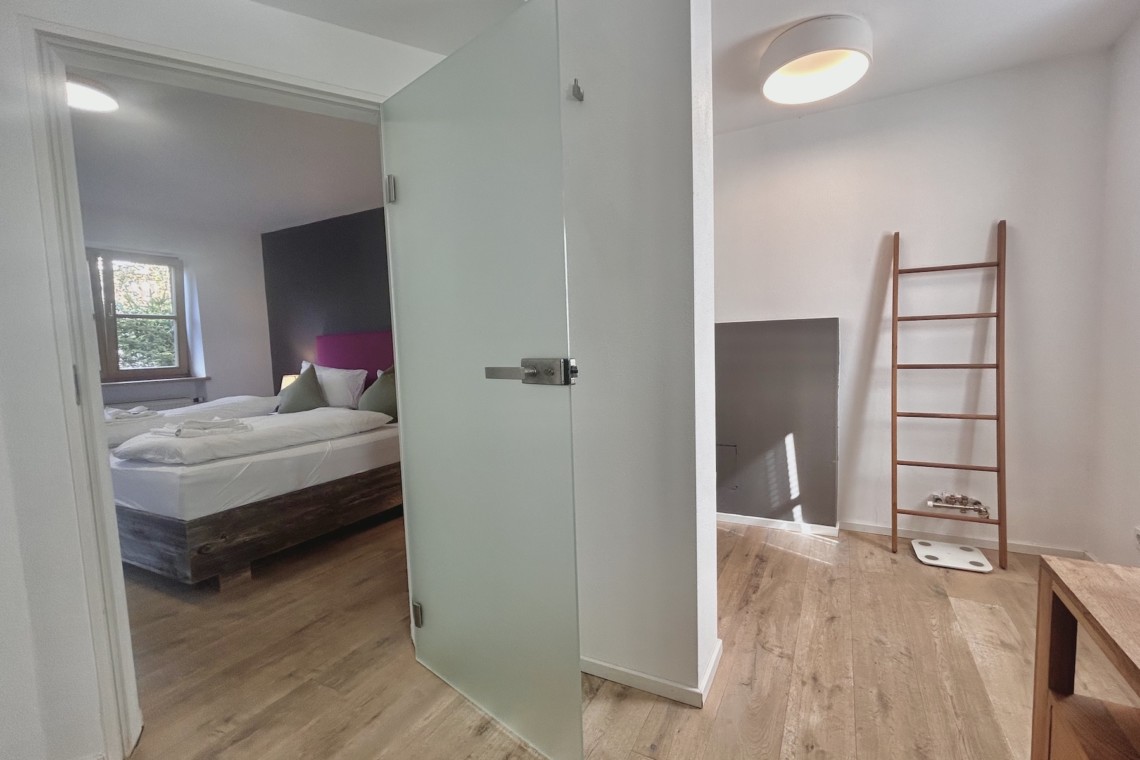 Moderne Ferienwohnung mit stilvollem Schlafzimmer, Holzböden und gemütlichem Ambiente. Ideal für Urlaubsauszeit.