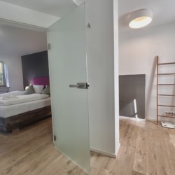 Moderne Ferienwohnung mit stilvollem Schlafzimmer, Holzböden und gemütlichem Ambiente. Ideal für Urlaubsauszeit.