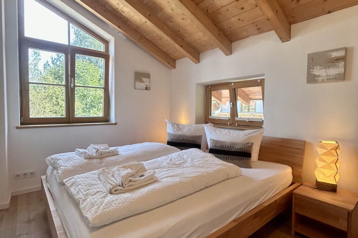 Gemütliches Schlafzimmer in Ferienhaus Seeblick mit Holzbalkendecke und charmantem Dekor, ideal für Erholung.