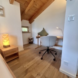 Gemütliches Arbeitszimmer in Ferienhaus mit Holzdecke, hellem Interieur und modernem Schreibtisch – ideal für entspannte Auszeit.