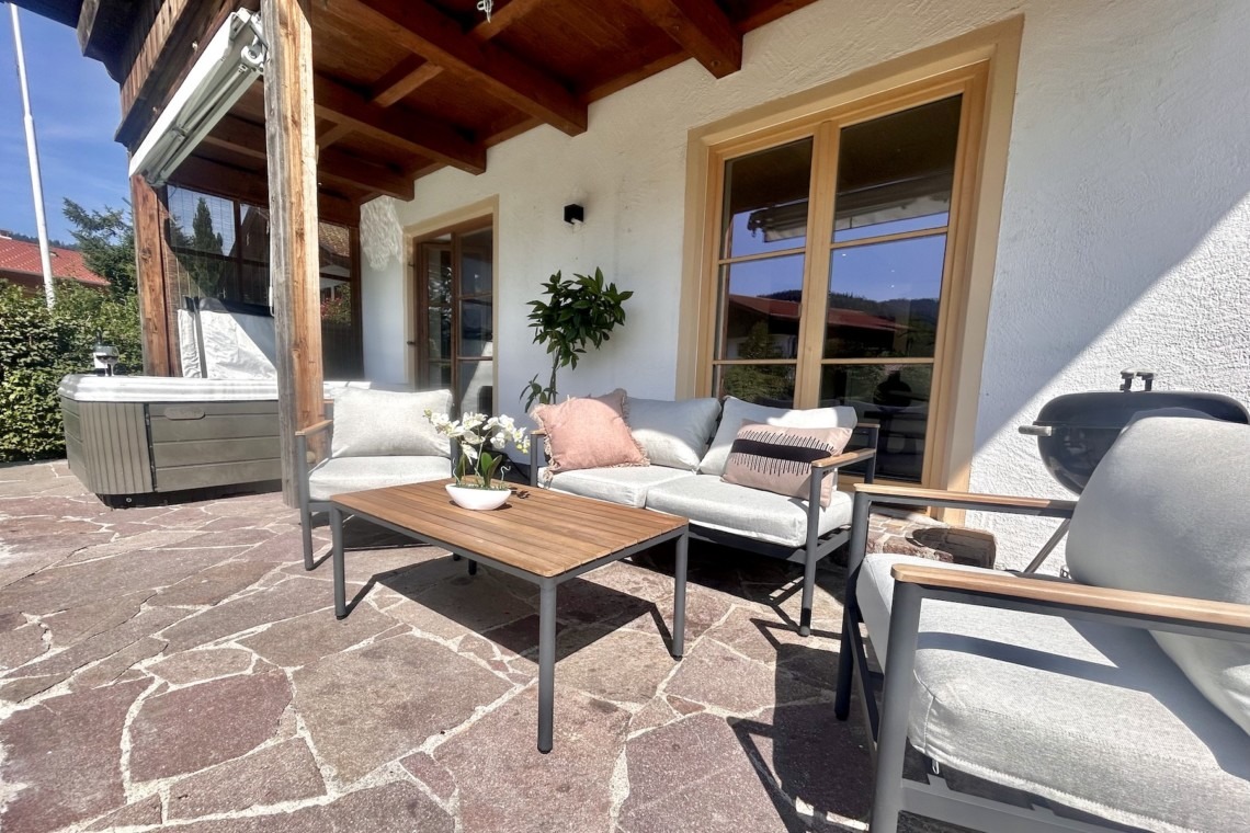 Terrasse im Ferienhaus Seeblick mit bequemen Sitzmöbeln und Whirlpool, ideal für Erholung im Freien.